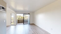 Located in San Diego, CA, this two-story residence offers 2 bedrooms and 3 bathrooms thoughtfully distributed across two floors of equal proportion. The main level features a bright, open living room with light wood-style flooring and sliding glass doors that open onto a private balcony, offering pleasant views of surrounding greenery. The galley-style kitchen is well-appointed with white cabinetry, a double basin sink, a dishwasher, a coil-top electric range, and a ceiling fan that adds airflow and character. Ample upper and lower cabinet storage keeps the space organized and efficient. The upper floor houses both bedrooms, each carpeted for comfort. The primary bedroom is a generous size, featuring a ceiling fan, wide windows with tree-lined views, and access to a dedicated closet with built-in shelving rods. The second bedroom is bright and airy with natural light filtering through a window overlooking the outdoors. Three bathrooms serve the home, including a clean, simply finished bath with a stone-topped vanity and tub-shower combination. Throughout, the interior maintains a clean, neutral palette of white walls and light flooring, lending a fresh and versatile aesthetic well-suited to a variety of living arrangements.