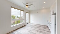 Located at 5460 N Interstate Ave in Portland, Oregon, this thoughtfully designed one-bedroom, one-bathroom unit offers a bright and efficient layout across a single floor. The open living area is the heart of the space, showcasing light-toned hardwood flooring, crisp white walls, and abundant natural light streaming through large windows. A brass-accented ceiling fan adds a modern yet warm touch overhead, complemented by recessed lighting. A glass balcony door opens to an outdoor space with views of the surrounding tree canopy and neighborhood rooftops, including a glimpse of a classic Portland water tower. The integrated kitchen lines one wall with sleek white cabinetry, open shelving, a stainless steel sink, and built-in appliances, maintaining a seamless and uncluttered aesthetic. The bedroom is a cozy, well-defined retreat featuring a built-in closet with wire shelving for organized storage and continued hardwood flooring. The bathroom is finished in a clean, contemporary style with a floating white vanity, white quartz countertop, an undermount sink with a chrome faucet, a frameless mirror, and a window that brings in natural light. The overall ambiance is modern, minimal, and move-in ready.