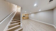 Located at 711 W 32nd St in Austin, TX, this two-story, 2-bedroom, 1-bathroom home offers a thoughtfully designed layout split evenly across two floors. Light wood-tone flooring flows throughout, complementing the neutral warm-gray and beige wall tones that give the space a clean, modern feel.

The main level houses an open kitchen and living area. The kitchen is well-appointed with light maple cabinetry, light-toned countertops, a peninsula with pendant lighting, stainless steel appliances including a refrigerator and microwave, a black range, and a dishwasher. The adjacent living area features recessed lighting, a front-facing window for natural light, and a private entry door.

The upper floor is home to both bedrooms, a hallway, and the shared bathroom. The spacious primary bedroom includes a ceiling fan, a large window with views of surrounding greenery, and an open closet. The second bedroom also features a ceiling fan, a window allowing ample natural light, and its own closet. The full bathroom offers a tiled tub-shower combination. Each floor is connected by a staircase visible from the main living area, adding a sense of vertical openness to the home's compact but efficient footprint.