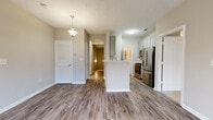 Located at 407 Carlton Park Dr in Flowood, Mississippi, this two-story home offers a practical and well-designed layout across three bedrooms and two bathrooms. The main living level features an open-concept floor plan where the living room flows seamlessly into the kitchen. The living area is finished with wood-look luxury vinyl plank flooring and includes a ceiling fan, while large windows allow natural light to brighten the space.

The kitchen is equipped with stainless steel appliances — including a refrigerator, range, microwave, and dishwasher — complemented by gray shaker-style cabinetry, a subway tile backsplash, white countertops, and a central kitchen island with a pendant light overhead.

The bedrooms are carpeted and feature ceiling fans and windows with blinds that bring in natural light. The spacious primary bedroom includes its own dedicated closet. The two bathrooms are finished with wood-look flooring, gray vanities, and white countertops. One bathroom features a tub/shower combo with tiled surround, while the other offers a stand-alone shower. An attached garage with a concrete floor and automatic opener provides convenient parking and additional storage. Neutral wall tones throughout give the home a clean, move-in-ready feel.