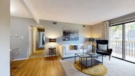 Located at 11413 Grandview Rd in Kansas City, MO, this single-floor, 2-bedroom, 2-bathroom residence offers a practical and well-organized layout. The combined living and dining area serves as the heart of the home, featuring hardwood-style flooring and neutral gray walls that create a clean, modern aesthetic. The living area is brightened by a sliding glass door that opens onto a private balcony, allowing natural light to fill the space and providing outdoor views. A dedicated dining nook off the main living area includes overhead lighting and wood-style flooring, offering a distinct space for meals.

The galley-style kitchen is efficiently designed with white cabinetry, dark countertops, a stainless steel sink, and black appliances, maximizing storage and functionality. A hallway connects the main living areas to the bedrooms and bathrooms, with wood-style flooring running its length. Both bedrooms are carpeted and feature open closets with built-in shelving. The primary bedroom includes a window with outdoor views. The bathrooms are finished with light gray walls, white vanities, and shower-curtain enclosures. Throughout, textured ceilings and consistent neutral tones contribute to a cohesive, understated interior.