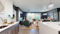 Located in Henderson, NV, this thoughtfully designed 3-bedroom, 3-bathroom residence offers a contemporary open-concept layout across a single floor. The combined kitchen and living area serves as the heart of the home, featuring wood-look flooring, bold dark accent walls, and a sliding glass door that floods the space with natural light while providing access to a private balcony with palm tree views. The kitchen is well-appointed with rich dark wood cabinetry, a mosaic tile backsplash, stainless steel appliances, and a generous center island with quartz countertops and seating for casual dining, illuminated by elegant crystal pendant lights. The living area flows seamlessly into a dining space, enhanced by a matching chandelier and ceiling fan. Each bedroom is generously proportioned, with the spacious primary suite featuring large windows, a ceiling fan, and a dedicated en-suite bathroom complete with a glass-enclosed walk-in shower and illuminated mirrors. Additional bathrooms are equally refined, each with dark wood vanities, quartz counters, and glass shower enclosures. A dedicated laundry room with full-size washer and dryer adds everyday convenience. The overall aesthetic is modern and polished throughout.