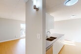 Located at 450 Victoria Ave in Windsor, Ontario, this one-bedroom, one-bathroom unit offers a thoughtfully designed layout across a single floor. The space features warm hardwood-style flooring throughout the living areas, complemented by light grey walls and tile-panel ceilings that create a clean, modern aesthetic.

The galley-style kitchen is efficiently arranged with floor-to-ceiling white cabinetry on both sides, grey countertops, a double basin sink, stainless steel appliances including a refrigerator, stove, and built-in microwave, and a dishwasher. The kitchen opens directly into the combined living area, which benefits from a sliding glass door that invites natural light and provides access to an outdoor space.

The bedroom is a well-proportioned room with soft grey walls, hardwood-style flooring, and a window overlooking a tree-lined streetscape, offering a calm, natural view and a baseboard heating unit below.

The bathroom is finished in a clean, contemporary style with light tile flooring, a white vanity with grey countertop, a large mirror, and a full shower-tub combination with a sliding glass door and white subway tile surround. The overall ambiance of the unit is bright, minimal, and move-in ready.