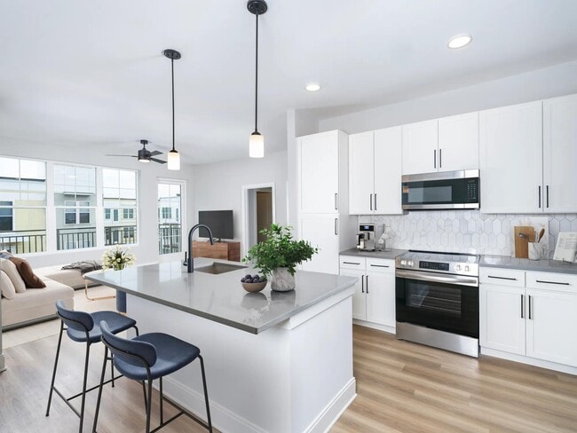 Our alternative option features fresh white cabinets with black hardware, gray quartz counters, and vertical, precious Calacatta Florida tile. - MAA Liberty Row