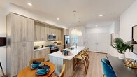 This well-appointed 2-bedroom, 2-bathroom single-story residence in Phoenix, AZ offers a thoughtfully designed open-concept layout. The kitchen is a standout feature, showcasing light wood-tone cabinetry extending floor to ceiling, stainless steel appliances including a French door refrigerator and range, white quartz countertops, and a center island with an undermount sink and bar seating illuminated by globe pendant lights. Light wood-look flooring flows seamlessly from the kitchen into the adjacent dining and living areas, creating a cohesive and airy feel throughout. The living room provides a comfortable retreat with natural light filtering through windows. Both bedrooms are well-sized, with the primary bedroom offering a ceiling fan, ample natural light, and dedicated closet space. The primary bathroom features a generous vanity with quartz countertops and a walk-in glass shower, while the second bathroom includes a full tub-shower combination. Clean white walls, recessed lighting, and modern hardware contribute to the home's contemporary aesthetic. Two closets provide practical storage solutions throughout the space.