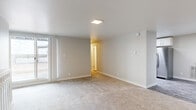 Located at 810 Oxford Ln in Colorado Springs, Colorado, this single-floor residence offers a well-designed layout with a clean, neutral aesthetic throughout. The open living area is finished with plush carpeting, soft neutral wall tones, and a flush skylight-style ceiling fixture that keeps the space feeling bright and airy. Sliding glass doors lead out to a spacious wooden deck, bringing in natural light and providing open outdoor views of the Colorado landscape.

The bedrooms continue the carpeted flooring and are each equipped with modern ceiling fans featuring wood-toned blades. One bedroom includes direct sliding door access to the deck, enhancing the indoor-outdoor connection.

The galley-style kitchen is a standout feature, showcasing white shaker cabinetry with brushed hardware, a mosaic tile backsplash, dark countertops, and a full suite of stainless steel appliances including a refrigerator, range, microwave, and dishwasher. Light wood-look vinyl flooring and a skylight overhead give the kitchen a bright, updated feel.

The bathroom is finished with warm beige tile surrounding the tub-shower combination, accented by a decorative mosaic tile border, and complemented by wood-look flooring. Throughout the home, consistent finishes and a neutral palette create a cohesive, move-in-ready atmosphere.