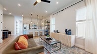 Located at 902 N Academy Ave in New Braunfels, TX, this well-appointed two-story home offers 3 bedrooms and 3 bathrooms across two evenly distributed floors. The main level welcomes you with an open-concept living and kitchen area bathed in natural light from large windows dressed with flowing curtains. Light hardwood floors run throughout, complementing the bright, neutral palette. The kitchen is a standout feature, boasting granite countertops, grey shaker-style cabinetry, stainless steel appliances, a tile backsplash, and a breakfast bar with pendant lighting — ideal for casual dining and entertaining. The living area is generously sized, anchored by a ceiling fan and open staircase that adds architectural interest. An attached garage with interior access and a dedicated laundry room add everyday convenience. Upstairs, the layout includes three bedrooms, each with closet space and carpeted flooring. The well-lit secondary bedroom functions easily as a home office or guest room, featuring a built-in closet and large window. The primary bedroom offers a comfortable, private retreat. Three clean, well-finished bathrooms with white cabinetry and black hardware fixtures complete this thoughtfully designed home.