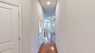 Located at 64 Setter Cir in Fredericksburg, VA, this well-appointed 2-bedroom, 2-bathroom residence offers a thoughtfully designed single-floor layout. Warm hardwood-style flooring flows throughout the main living areas and hallways, complemented by neutral-toned walls and recessed lighting that create a clean, modern aesthetic. The kitchen is a standout feature, boasting white shaker cabinetry, stainless steel appliances including a refrigerator, range, microwave, and dishwasher, a mosaic tile backsplash, and a central island with a light countertop — all illuminated by stylish pendant lighting. An adjacent dining area is bathed in natural light from multiple large windows dressed with horizontal blinds. Both bedrooms are carpeted and feature ceiling fans and windows that allow ample natural light. The primary bedroom includes a generously sized walk-in closet outfitted with wire shelving. The bathrooms are finished with hardwood-style flooring and include a tub/shower combination with white tile surround and brushed nickel fixtures. A louvered-door closet in the hallway provides additional storage. The overall ambiance is bright, clean, and move-in ready.