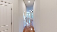Located at 64 Setter Cir in Fredericksburg, VA, this well-appointed 2-bedroom, 2-bathroom residence offers a thoughtfully designed single-floor layout. Warm hardwood-style flooring flows throughout the main living areas and hallways, complemented by neutral-toned walls and recessed lighting that create a clean, modern aesthetic. The kitchen is a standout feature, boasting white shaker cabinetry, stainless steel appliances including a refrigerator, range, microwave, and dishwasher, a mosaic tile backsplash, and a central island with a light countertop — all illuminated by stylish pendant lighting. An adjacent dining area is bathed in natural light from multiple large windows dressed with horizontal blinds. Both bedrooms are carpeted and feature ceiling fans and windows that allow ample natural light. The primary bedroom includes a generously sized walk-in closet outfitted with wire shelving. The bathrooms are finished with hardwood-style flooring and include a tub/shower combination with white tile surround and brushed nickel fixtures. A louvered-door closet in the hallway provides additional storage. The overall ambiance is bright, clean, and move-in ready.