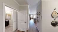 Located at Wolf Ranch in Georgetown, TX, this thoughtfully designed one-bedroom, one-bathroom residence offers a cohesive open-concept layout that maximizes every square foot. Rich hardwood-style flooring flows through the main living areas, complemented by neutral warm-gray walls and detailed crown molding that lend a refined, polished character throughout.

The combined kitchen and living area forms the heart of the home. The kitchen features dark espresso cabinetry, a subway tile backsplash, stainless steel appliances, and a granite-topped island with bar seating — ideal for both casual dining and entertaining. Stylish pendant lighting illuminates the space. The living room benefits from multiple windows and a glass-panel door that invite natural light and offer exterior views, creating an airy, welcoming atmosphere.

A dedicated dining area provides additional flexibility for the layout. The hallway, accented with decorative wall art, connects the living spaces to the private bedroom, which is generously sized and features plush carpeting and a ceiling fan. A dedicated closet provides organized storage.

The bathroom is finished with neutral tile flooring, a shower with curtain, and clean, classic fixtures. The overall design reflects a balance of modern comfort and understated elegance, making this residence a functional and attractive home.