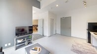 Located on the third floor of a modern building in downtown Hamilton, Unit 306 at 20 Rebecca Street is a thoughtfully designed one-bedroom unit offering an efficient and functional layout. The space includes a bedroom, bathroom, and a dedicated office area across a single floor.

The open living area greets you upon entry, featuring large floor-to-ceiling windows that flood the space with natural light and offer views of the surrounding urban streetscape. Light-toned tile flooring runs throughout the main living area, contributing to a clean, contemporary aesthetic. The living space accommodates both a seating area and a compact dining setup, making efficient use of the available footprint.

The bedroom is a well-proportioned private retreat, also benefiting from expansive floor-to-ceiling windows with city views. Carpeted flooring adds warmth underfoot, and built-in storage provides practical organization. A dedicated office space offers additional flexibility for work or study.

The bathroom is designed with accessibility in mind, featuring a spacious roll-in shower finished with dark square tiles, stainless steel grab bars, a handheld showerhead, and a fold-down bench. A colorful curtain adds a touch of personality to the space.

Overall, this unit presents a modern, urban living environment with practical amenities and strong natural light throughout.