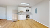 Located at 600 Sherman Street in Akron, Ohio, this efficient one-bedroom, one-bathroom unit offers a thoughtfully designed layout across a single floor. Warm hardwood-style flooring flows continuously throughout the space, creating a cohesive and clean aesthetic.

The kitchen is a standout feature, outfitted with crisp white shaker cabinetry, light granite countertops, and a full suite of stainless steel appliances including a refrigerator, electric range, and built-in microwave. A flush ceiling light fixture brightens the cooking area, and an accessible electrical panel is neatly integrated into the wall.

The bedroom offers a comfortable footprint with soft gray walls, a double-door closet providing generous storage, and two windows that invite an abundance of natural light and views of the surrounding neighborhood.

The bathroom maintains the clean, modern palette of the rest of the unit, featuring a white vanity with under-cabinet storage, a combination tub and shower, and hardwood-style flooring that ties the space together.

Throughout the unit, neutral gray walls, white trim, and consistent flooring lend a fresh, move-in-ready feel. The open flow between the main living area and kitchen maximizes the sense of space, making this a practical and well-appointed unit in Akron's South Side neighborhood.