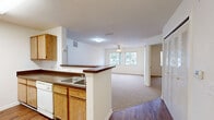 This single-floor, 3-bedroom, 2-bathroom residence offers a practical and comfortable layout designed for everyday living. The open-concept kitchen and living area form the heart of the home, where warm oak cabinetry, dark laminate countertops, and white appliances — including a gas range, dishwasher, and full-size refrigerator — define a functional galley-style kitchen. A peninsula with a double-basin sink overlooks the adjoining living area, which features durable wood-look flooring that transitions into plush neutral carpeting. The living area is bright and airy, benefiting from natural light through a large window, and is accented by a ceiling fan overhead.

The three bedrooms are carpeted and well-proportioned, with the primary bedroom offering a comfortable footprint alongside ceiling fan and natural light. A dedicated closet features built-in wire shelving for organized storage. Both bathrooms are finished with light tile flooring, oak vanities with dark countertops, and full mirrors. One bathroom is equipped with accessibility features, including grab bars around the tub-shower combination and toilet. A hallway connects the bedrooms and bathrooms seamlessly, completing the efficient and accessible floor plan.