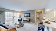 Located at 1225 Deerfield Parkway in Buffalo Grove, IL, this single-floor residence offers a thoughtfully designed layout across two bedrooms and two bathrooms. The open-concept living area is carpeted and bathed in natural light from a large sliding glass door fitted with vertical blinds, creating a welcoming and airy atmosphere. The kitchen is a standout feature, boasting white shaker cabinetry, stainless steel appliances including a refrigerator, range, and microwave, and a light-toned countertop with a peninsula that flows seamlessly into the dining area. Both bathrooms are clean and functional, with one featuring a tub-shower combination, wood-look luxury vinyl flooring, white cabinetry, and a backlit vanity mirror. The spacious primary bedroom features plush carpeting, neutral-toned walls, and a window with outdoor views, while the second bedroom offers a similarly comfortable and cozy setting with ample natural light. A walk-in closet with wire shelving provides generous storage. The dedicated laundry room houses a full-sized washer and dryer with overhead cabinetry for added convenience. Throughout the residence, a cohesive neutral color palette and modern finishes create a polished and livable environment.