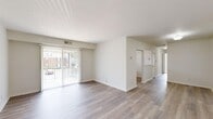 Located at 25 Woodmere Dr in Petersburg, Virginia, this single-floor residence offers a functional and efficient layout across two bedrooms and two bathrooms. The open living area is a standout feature, showcasing light-toned wood-look flooring and bright white walls that create a clean, airy atmosphere. A full-length sliding glass door fitted with vertical blinds floods the space with natural light and provides direct outdoor views, enhancing the sense of openness throughout.

The kitchen is equipped with warm oak cabinetry, a gas range, a dishwasher, and a double-basin sink positioned beneath a window — providing both practicality and natural light during meal preparation. Upper and lower cabinetry offer ample storage space.

The two bedrooms are carpeted in a neutral tone, providing comfort underfoot. The primary bedroom is generously sized and features a window with outdoor views. The secondary bedroom includes a set of louvered bi-fold closet doors, offering organized storage. A connecting hallway links the bedrooms to the rest of the unit.

Both bathrooms are finished in white, with one featuring a white vanity with a clean countertop, and the other offering a full bathtub and shower combination. The overall design is straightforward and well-maintained, making this residence a comfortable and practical living space.
