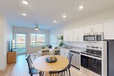 Located at 2549 Williams St in Chattanooga, TN, this thoughtfully designed one-bedroom, one-bathroom residence offers a clean, modern aesthetic across a single floor. The open-concept layout seamlessly connects the kitchen, dining area, and living room, creating a cohesive and functional living space. The kitchen is outfitted with white shaker cabinets, granite countertops, a stainless steel appliance suite including a refrigerator, electric range, microwave, and dishwasher, and light wood-look flooring that extends throughout the main living areas. A round dining table nestled adjacent to the kitchen provides a natural transition into the bright living room, which features a ceiling fan, large windows, and a glass door opening to a private balcony with outdoor views. The bedroom is a comfortable retreat with ample natural light from a wide window, a ceiling fan, and light wood flooring. The bathroom is finished with granite countertops, white cabinetry, a large mirror, and a tub-shower combination. Recessed lighting throughout the home enhances the clean, contemporary ambiance, making this Chattanooga residence both stylish and practical.