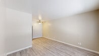 This single-story 2-bedroom, 1-bathroom unit offers a well-organized layout designed for efficient, comfortable living. The living room features light wood-style laminate flooring, warm neutral-toned walls, and a ceiling fan with light fixture, creating a bright and airy atmosphere. A sliding glass door fitted with vertical blinds allows natural light to filter in and provides outdoor access.

The kitchen is laid out in a galley style, featuring white cabinetry with decorative scalloped detailing, light countertops, a stainless steel refrigerator, and a black electric range with an overhead exhaust hood. Light wood-style flooring continues throughout, and a flush-mount ceiling light provides functional illumination.

Both bedrooms are carpeted in a neutral beige tone, offering a soft and comfortable feel underfoot. Each room receives natural light through windows with blinds. The primary bedroom is a well-proportioned space, while the second bedroom provides versatility for guests or a home office. Two closets serve the unit's storage needs.

The full bathroom includes a tub-shower combination with white tile surround, a chrome grab bar, and wood-style flooring. A central hallway connects the rooms, contributing to a logical and easy-to-navigate floor plan. The unit maintains a clean, move-in-ready aesthetic throughout with consistent neutral finishes.