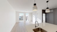 Located at 773 E McMillan St in Cincinnati's vibrant East Walnut Hills neighborhood, this single-floor residence offers a thoughtfully designed, open-concept layout filled with natural light. The living area features light-toned luxury vinyl plank flooring, crisp white walls, and large windows and a glass door that flood the space with sunlight while providing access to an outdoor area. Stylish pendant lighting anchors the space, adding a modern touch overhead.

The kitchen is well-appointed with white shaker-style cabinetry extending to the ceiling for ample storage, light-toned countertops, a stainless steel undermount sink, and a full suite of stainless steel appliances including a refrigerator, electric range, and over-the-range microwave. A peninsula with seating potential connects the kitchen seamlessly to the living area.

The bedroom is carpeted for comfort and features a large window with blinds that allows generous natural light and outdoor views. The bathroom is clean and functional, finished with wood-look flooring and a tub-shower combination. A stacked washer and dryer unit is conveniently located within the bathroom, offering in-unit laundry without sacrificing additional living space. Overall, the unit presents a clean, modern aesthetic with practical, contemporary finishes throughout.