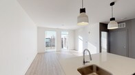 Located at 773 E McMillan St in Cincinnati's vibrant East Walnut Hills neighborhood, this single-floor residence offers a thoughtfully designed, open-concept layout filled with natural light. The living area features light-toned luxury vinyl plank flooring, crisp white walls, and large windows and a glass door that flood the space with sunlight while providing access to an outdoor area. Stylish pendant lighting anchors the space, adding a modern touch overhead.

The kitchen is well-appointed with white shaker-style cabinetry extending to the ceiling for ample storage, light-toned countertops, a stainless steel undermount sink, and a full suite of stainless steel appliances including a refrigerator, electric range, and over-the-range microwave. A peninsula with seating potential connects the kitchen seamlessly to the living area.

The bedroom is carpeted for comfort and features a large window with blinds that allows generous natural light and outdoor views. The bathroom is clean and functional, finished with wood-look flooring and a tub-shower combination. A stacked washer and dryer unit is conveniently located within the bathroom, offering in-unit laundry without sacrificing additional living space. Overall, the unit presents a clean, modern aesthetic with practical, contemporary finishes throughout.
