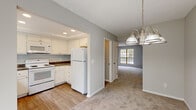 Located at 1363 Hideaway Woods Dr in Westerville, Ohio, this three-floor home offers a well-organized layout designed for comfortable everyday living. The main level features a kitchen equipped with white cabinetry, dark granite-style countertops, a tray ceiling with recessed lighting, and wood-look flooring. White appliances including a refrigerator, electric range, built-in microwave, and dishwasher are included. The kitchen opens directly to a dining area illuminated by a brushed nickel chandelier, which flows into a carpeted living room featuring a fireplace and a large multi-pane window that invites natural light. The upper level includes carpeted bedrooms, one of which features vaulted ceilings, a sliding closet, and a window overlooking the surrounding greenery. Additional bedrooms are bright and well-proportioned with neutral walls and carpet. A full bathroom on this level features wood-look flooring, a white vanity, and a tub-shower combination. The lower level provides an unfinished basement with painted concrete floors, exposed joists, a water heater, and an electrical panel, offering considerable potential for customization or additional storage. Throughout the home, neutral tones and clean finishes create a bright, move-in ready atmosphere.