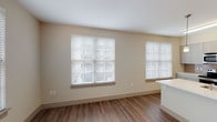 This thoughtfully designed 2-bedroom, 2-bathroom residence offers a functional and comfortable single-floor layout with contemporary finishes throughout. The open living area features warm wood-look plank flooring and large windows dressed with white horizontal blinds, filling the space with generous natural light and creating a bright, welcoming ambiance.

The kitchen is well-appointed with sleek, light-toned cabinetry, white quartz countertops, and a full suite of stainless steel appliances including a refrigerator, electric range, and built-in microwave. A kitchen island provides additional prep and dining space, while a window above the sink adds extra light to the area.

Both bedrooms are carpeted for comfort and each features a ceiling fan with light fixture and a window with blinds that allows natural light to filter in. The rooms offer a calm, neutral palette ideal for rest and relaxation.

The two bathrooms are finished with tile flooring and clean white walls. The full bathroom showcases a subway-tiled tub and shower surround, a modern wood-toned vanity with white countertop, and stylish wall sconce lighting. The second bathroom is similarly clean and functional, complete with tile flooring and a vanity with white countertop.