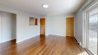Located at 321 Crowells Rd in Highland Park, NJ, this single-floor home offers three bedrooms, two bathrooms, a combined kitchen and living area, and a connecting hallway. Warm hardwood flooring flows throughout most of the home, lending a cohesive and inviting feel to each room.

The living room is bright and open, featuring sliding glass doors that lead to a private outdoor balcony, filling the space with natural light. The kitchen is thoughtfully updated with modern two-tone cabinetry — white uppers paired with natural wood lowers — stainless steel appliances including a gas range, over-range microwave, and dishwasher, plus clean white countertops and a subway tile backsplash.

The primary bedroom is comfortably sized and includes a ceiling fan, a wall-unit air conditioner, and access to natural light through a window. Two additional bedrooms offer flexible living arrangements; one features ceiling fan lighting and multiple closet doors, while another is carpeted with baseboard heating. Each room is finished with neutral gray walls throughout.

The two bathrooms differ in style: one is bright and clean with a classic tub-shower combo and white tile surround, while the other features a sleek glass-enclosed shower stall with modern large-format gray tile and built-in shelving, offering a more contemporary feel.