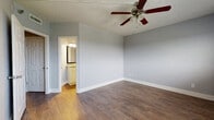 This single-story, two-bedroom, two-bathroom residence offers a functional and cohesive design highlighted by warm wood-look flooring that runs throughout the entire unit. The layout is connected by a hallway with textured walls and ceilings, leading to each of the main living areas.

The kitchen is equipped with white shaker-style cabinetry, granite countertops, a stainless steel sink, and stainless steel appliances including a range, dishwasher, and microwave — providing a practical and modern workspace.

Both bedrooms feature the same consistent wood-look flooring and neutral gray walls. The primary bedroom includes a ceiling fan with light fixture and direct access to an en-suite bathroom. Windows fitted with horizontal blinds allow natural light and outdoor views into the bedrooms.

Each bathroom is finished with wood-look flooring, white cabinetry, granite countertops, framed mirrors, and a tub-shower combination with tile surround. Textured ceilings are found throughout the unit, maintaining a consistent aesthetic. Overall, the space offers a clean, neutral palette well-suited for comfortable everyday living.
