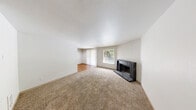This one-bedroom, one-bathroom unit in Tacoma, Washington offers a thoughtfully arranged single-floor layout designed to maximize everyday comfort. The combined kitchen and living room serves as the heart of the home, where plush wall-to-wall carpeting and neutral walls create a warm, inviting atmosphere. A standout feature of the living area is the dark stone wood-burning fireplace, adding both character and coziness to the space. Natural light flows in through a window and sliding glass door that opens directly onto a private balcony, offering a pleasant outdoor retreat with views of surrounding greenery.

The galley-style kitchen is efficiently designed with ample cabinetry in a warm cream finish, light countertops, a double stainless steel sink, and white appliances including an electric range and refrigerator. Warm hardwood flooring runs throughout the kitchen, dining area, and bathroom, providing a clean contrast to the carpeted living and sleeping spaces.

The bedroom is a comfortable, well-lit room featuring carpet flooring, a baseboard heater, and a window that frames views of the outdoors. A dedicated closet provides practical storage. The full bathroom is clean and functional, featuring a tub-shower combination, a single vanity with storage, and hardwood flooring. This unit offers a well-rounded layout suited for single occupants or couples.