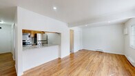 Located at 587 Broadway in Menands, NY, this efficiently designed unit offers a thoughtful layout across a single floor, incorporating a living room, kitchen, bathroom, and closet. Warm hardwood flooring runs throughout the living area, reflecting natural light that filters in through a windowed exterior door, lending the space a bright and inviting atmosphere. Recessed lighting and baseboard heating add comfort and practicality throughout.

The kitchen is designed in a galley style, featuring warm wood cabinetry, light granite countertops with a tile backsplash, and a full suite of stainless steel appliances including a refrigerator, electric range, and built-in microwave. A pass-through counter connects the kitchen to the living area, creating an open and airy feel despite the compact footprint.

The living room is clean and open, with crisp white walls that enhance the sense of space. A dedicated closet provides valuable storage. The bathroom is finished with clean white square tile surrounding a full tub-shower combination with brushed nickel fixtures, delivering a simple and functional design. Overall, this unit presents a well-maintained, move-in-ready space with a cohesive and practical aesthetic.