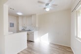 Located at 10780 Crenshaw Blvd in Inglewood, CA, this 2-bedroom, 1-bathroom residence offers a practical and well-organized single-floor layout. The interior is finished in a clean, neutral palette throughout, creating a bright and cohesive atmosphere.

The living area features light wood-look flooring and a ceiling fan with integrated lighting, allowing for comfortable airflow and illumination. It flows naturally toward the kitchen, which is separated by a half-wall partition. The galley-style kitchen is well-equipped with ample white cabinetry above and below the counter, a built-in sink, a dishwasher, and a dedicated utility panel. A secondary counter space provides additional prep or storage functionality.

Both bedrooms are carpeted and offer a quiet, comfortable setting. The primary bedroom includes a reach-in closet and a window with natural light and neighborhood views. The second bedroom connects conveniently to the hallway. The full bathroom features a tub-shower combination with white tile surround, chrome fixtures, and a window that brings in natural light.

A connecting hallway ties the rooms together efficiently. The overall design prioritizes functionality and clean finishes, making this a straightforward and move-in ready residence in a well-connected Inglewood location.