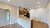 Located at 707 W Center St in Rogersville, Missouri, this single-floor 2-bedroom, 2-bathroom residence offers a well-designed layout with modern finishes throughout. The open-concept kitchen flows seamlessly into the combined dining and living area, creating a bright and connected living space. The kitchen is outfitted with rich dark espresso cabinetry, granite-style countertops, a peninsula with a double-basin sink, and black appliances including a range, dishwasher, microwave, and refrigerator. Wood-look flooring runs through the main living areas, adding warmth and durability. Recessed lighting illuminates the kitchen and living space, while large windows allow for ample natural light. Each bedroom features plush carpeting and a ceiling fan, with access to a closet and its own bathroom — providing a private and functional suite-style setup. The primary bedroom includes a walk-in closet with wire shelving. The bathrooms are finished with dark wood vanities, marble-style countertops, and full tub-shower combinations. A dedicated laundry area adds everyday convenience. Two closets throughout the unit provide generous storage for a space of this size.