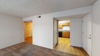 Located at 3940 Apache Trail in Nashville, TN, this single-floor unit offers a practical and well-organized layout across several distinct living spaces. The living area is finished with wall-to-wall carpet and neutral-toned walls, creating a clean and versatile environment. Large sliding glass doors in the main living space allow for generous natural light and provide outdoor access. The kitchen is a functional highlight, featuring warm honey-toned wooden cabinetry extending to the upper walls, dark appliances including a refrigerator, dishwasher, and range, along with a double sink and laminate countertops. Light wood-style flooring ties the kitchen together and extends into the adjacent entry and hallway areas. The bedrooms are carpeted and bright, each benefiting from windows fitted with blinds that allow natural light to filter in. One bedroom is accompanied by a private en-suite bathroom, which includes a wide vanity with a single-basin sink, a large mirror, and a shower/tub combination. A textured popcorn ceiling is consistent throughout the unit, complementing the neutral wall palette. The overall layout flows efficiently, with clearly defined transitions between the main living zone, kitchen, and private sleeping quarters.