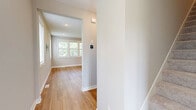 Located at 20457 Keystone Ave in Lakeville, MN, this three-floor home offers four bedrooms, five bathrooms, and a thoughtfully designed layout spread across three distinct levels. The main floor features an open-concept kitchen and living area anchored by white shaker cabinetry, quartz-style countertops, stainless steel appliances, a central island with pendant lighting, and light hardwood flooring that flows throughout the space. Large windows flood the living areas with natural light and frame views of the surrounding greenery. The upper floor hosts the bedrooms, including a spacious primary suite with its own walk-in closet fitted with wire shelving and an en-suite bathroom featuring a sleek glass-panel shower with black frame accents and light hardwood flooring. Additional bedrooms are carpeted and bright, each benefiting from large windows with outdoor views. Four closets throughout the home provide ample storage. The lower level includes a generously sized garage with a concrete floor, drywall-finished walls, and interior access via a wooden staircase. A utility room, multiple hallways, and a dedicated entrance round out the functional layout. Neutral tones, recessed lighting, and clean finishes are consistent throughout, giving the home a modern, move-in-ready feel.