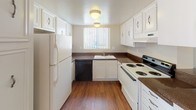 Located at 4395 70th Street in La Mesa, Unit #52 is a single-floor residence that offers a practical and comfortable layout. The living area features warm wood-look flooring and neutral-toned walls, creating a bright and welcoming atmosphere. A ceiling fan with a light fixture adds comfort, while a large window with vertical blinds allows natural light to filter in, offering a view of the surrounding greenery. The space flows seamlessly into a dedicated dining area, separated by a dark-countertop bar or partition.

The kitchen is well-appointed with white cabinetry, dark countertops, and a full suite of appliances including a refrigerator, electric range, dishwasher, and under-cabinet range hood. A window above the sink keeps the kitchen bright and ventilated.

The bedrooms are carpeted for comfort and feature neutral walls, windows with vertical blinds, and ceiling fans for climate control. One bedroom includes mirrored sliding closet doors, offering both storage and a sense of expanded space.

The bathroom features a dual-sink vanity with white cabinetry and dark countertops, wood-look flooring, and a separate water closet. Textured ceilings are consistent throughout the unit. The entryway is finished with tile flooring, providing a durable transition point into the home.