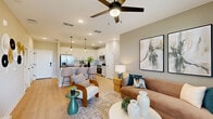 Located on Wellness Way in Clermont, FL, this single-floor, 2-bedroom, 2-bathroom residence offers a thoughtfully designed layout with contemporary finishes throughout. Light wood-look flooring flows seamlessly across the entire space, complementing the neutral color palette.

The kitchen is a standout feature, boasting white shaker cabinetry with matte black hardware, a striking hexagonal tile backsplash, quartz countertops, stainless steel appliances, and a central island with bar seating beneath pendant lighting. It opens directly into the living area, which is bright and welcoming, with large windows dressed in navy drapes that frame outdoor views and let in generous natural light. A ceiling fan adds comfort overhead.

The primary bedroom features a calming teal accent wall, large windows with outdoor views, and a sliding double-door closet. The en-suite bathroom includes a long vanity with ample storage, a glass-enclosed shower, and wood-look flooring. The second bedroom is equally well-lit, with wide windows and a ceiling fan. The second bathroom offers a full tub-shower combination with clean white tile and matte black fixtures, consistent with the home's modern design language. The overall ambiance is clean, contemporary, and inviting.