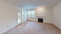 Located at 249 Marcliffe Dr in Valparaiso, Indiana, this single-floor home offers a practical and comfortable layout with a clean, neutral aesthetic throughout. The living room serves as the heart of the home, featuring a fireplace with a classic white mantel, soft carpeted flooring, and a glass-panel door that opens to the outdoors, allowing natural light to fill the space. Multiple windows frame views of the surrounding greenery, enhancing the room's bright and welcoming atmosphere. A dedicated dining area sits adjacent to the kitchen, lit by a pendant light fixture and open to the living space, creating a seamless flow ideal for everyday living and entertaining. The kitchen is efficiently designed with warm hardwood-style flooring, white cabinetry, a gas range, built-in microwave, and a full-size refrigerator, providing all essential appliances in a well-organized galley layout. The bedroom is a quiet, carpeted retreat featuring a ceiling fan with integrated lighting and a generously sized window that invites natural light. The bathroom is finished with tile flooring, a tub and shower combination, a wall-mounted medicine cabinet, and clean white fixtures throughout, offering a functional and tidy space.