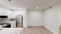 Located in Glendale, Arizona, this well-appointed 1-bedroom, 1-bathroom residence offers a thoughtfully designed single-floor layout with a clean, modern aesthetic throughout. Light wood-look flooring flows seamlessly across the living areas, complementing the bright, neutral color palette that creates an airy and welcoming atmosphere.

The open-concept kitchen and living area serves as the heart of the home. The kitchen is outfitted with crisp white shaker cabinetry, a neutral tile backsplash, stainless steel appliances including a refrigerator, range, and over-the-range microwave, and a striking quartz-topped peninsula that offers additional workspace and casual seating. Recessed lighting illuminates the space effectively.

The living room is highlighted by a marble-surround fireplace and a ceiling fan with light fixture. A sliding glass door opens to a private balcony, inviting natural light and outdoor views into the space.

The spacious bedroom features wood-look flooring, a ceiling fan, a closet with a paneled door, and a window that brings in natural light. The full bathroom is finished with matte black fixtures, a combination tub and shower, a white vanity, and wood-look flooring that ties into the overall design language.

A hallway connects all rooms, completing this cohesive and move-in ready layout.