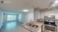 Located at 1718 Palmer St in Durham, NC, this single-floor, three-bedroom, one-bathroom home offers a functional and well-appointed layout. The open-concept kitchen and living area serves as the heart of the home, featuring granite countertops, white shaker-style cabinetry, a subway tile backsplash, and stainless steel appliances including a refrigerator, electric range, and dishwasher. A peninsula with a double-basin undermount sink connects the kitchen to the living area, which is finished with light-toned luxury vinyl plank flooring and benefits from natural light through large windows. A textured ceiling runs throughout the main living spaces. The three bedrooms are carpeted and neutral in tone, each offering closet space and windows that let in natural light—several with outdoor views. The primary bedroom provides a comfortable, well-sized retreat. The bathroom continues the granite aesthetic with a granite-topped vanity, undermount sink, and light wood-look flooring. Clean white trim and neutral wall tones throughout the home create a cohesive, move-in-ready feel that is both practical and inviting.