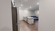 This well-designed single-floor unit offers four bedrooms and four bathrooms within a thoughtfully arranged floor plan. The open-concept kitchen and living area serves as the heart of the space, featuring white shaker-style cabinetry, a subway tile backsplash, granite countertops, and a large central island with bar seating — ideal for dining and entertaining. Stainless steel appliances, including a refrigerator, range, microwave, and dishwasher, complete the kitchen. Recessed lighting throughout the common areas enhances the clean, modern aesthetic. Wood-look flooring extends across the living and kitchen areas, adding warmth to the contemporary design. The living room is bright and welcoming, with a large window dressed in horizontal blinds that allows for natural light. Each bedroom is a comfortable, private retreat with wood-look flooring, ceiling fans, and windows with blinds. The primary bedroom offers a generous layout suited for a full furniture arrangement. The four bathrooms are finished consistently with granite-topped vanities, white cabinetry with matte black hardware, and tub-shower combinations featuring white tile surrounds and chrome fixtures. A connecting hallway ties all rooms together efficiently, creating a functional and cohesive living environment.