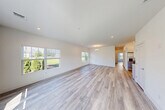 Located at 720 Eastview Dr in Central Islip, NY, this well-appointed 2-bedroom, 3-bathroom residence offers a thoughtfully designed single-floor layout. The open-concept living and dining area is a standout centerpiece, featuring light-toned hardwood flooring, crisp white walls, and multiple large windows that flood the space with natural light and offer pleasant views of the lush green surroundings. Recessed lighting and a classic chandelier add warmth to the combined living and dining zone.

The kitchen is outfitted with white shaker-style cabinetry, stainless steel appliances including a French door refrigerator, and clean countertops that make it both functional and visually appealing. The primary bedroom is generously sized, complete with an en-suite bathroom and closet access. The second bedroom also benefits from large windows with outdoor views. All three bathrooms are finished in a bright, clean aesthetic with marble-style tile surrounds, modern fixtures, and white vanity cabinetry. A dedicated laundry area and three closets add practical convenience. The exterior showcases well-maintained landscaping with mature trees and expansive green lawn, set within an attractive residential community.