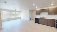 Located at 1009 Avenue L in Lubbock, TX, this 2-bedroom, 1-bathroom unit offers a thoughtfully arranged single-floor layout designed for comfortable, everyday living. The kitchen is a standout feature, showcasing rich dark-brown cabinetry with ample upper and lower storage, light countertops, recessed lighting, and full black appliance suite including a refrigerator, range, microwave, and dishwasher. Light-toned luxury vinyl flooring runs throughout the kitchen and common areas, creating a clean and cohesive aesthetic. Both bedrooms feature plush, neutral-toned carpet that adds warmth underfoot and are finished with crisp white walls and panel-style doors. The primary bedroom offers a comfortable footprint with a window fitted with blinds, allowing for natural light and privacy. The secondary bedroom includes a double-door closet, providing generous storage. A dedicated closet and utility room add to the functional storage options within the unit. The bathroom features tile-style flooring in soft neutral tones, maintaining the clean, contemporary feel found throughout. Overall, the unit presents a bright, move-in-ready environment with a modern finish palette suited for a variety of lifestyles.