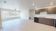 Located at 1009 Avenue L in Lubbock, TX, this 2-bedroom, 1-bathroom unit offers a thoughtfully arranged single-floor layout designed for comfortable, everyday living. The kitchen is a standout feature, showcasing rich dark-brown cabinetry with ample upper and lower storage, light countertops, recessed lighting, and full black appliance suite including a refrigerator, range, microwave, and dishwasher. Light-toned luxury vinyl flooring runs throughout the kitchen and common areas, creating a clean and cohesive aesthetic. Both bedrooms feature plush, neutral-toned carpet that adds warmth underfoot and are finished with crisp white walls and panel-style doors. The primary bedroom offers a comfortable footprint with a window fitted with blinds, allowing for natural light and privacy. The secondary bedroom includes a double-door closet, providing generous storage. A dedicated closet and utility room add to the functional storage options within the unit. The bathroom features tile-style flooring in soft neutral tones, maintaining the clean, contemporary feel found throughout. Overall, the unit presents a bright, move-in-ready environment with a modern finish palette suited for a variety of lifestyles.
