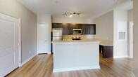Located at 110 29th Avenue Dr NW in Hickory, NC, this single-story, one-bedroom, two-bathroom residence offers a thoughtfully designed layout that maximizes every square foot of its compact footprint. The open-concept kitchen and living area forms the heart of the home, showcasing light hardwood-style flooring, neutral warm-toned walls, and a ceiling fan with integrated lighting. The kitchen is well-appointed with rich dark espresso cabinetry, light countertops, a stainless steel range, microwave, and refrigerator, along with a peninsula that provides additional prep space and casual seating. The bedroom is comfortably sized, featuring plush carpeting, a ceiling fan, a walk-in closet with built-in shelving, and a large window that invites natural light. French doors in an adjoining area open to an outdoor space, further brightening the interior. The two bathrooms are finished with dark wood vanities, light countertops, large mirrors, and hardwood-style flooring; one includes a full tub-shower combination. A dedicated closet provides additional storage. The overall ambiance is clean, modern, and move-in ready, with consistent finishes throughout that create a cohesive and welcoming environment.