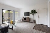 Located at 1142 Buckingham Dr in Costa Mesa, California, this single-floor residence offers a well-designed layout that balances comfort and functionality. The living room is bright and open, featuring plush carpeting, neutral walls, and a large sliding glass door that leads to a private balcony overlooking lush greenery — filling the space with natural light. Adjacent to the living area, the dining space accommodates intimate gatherings beneath a stylish pendant light, with a window framing outdoor views. The kitchen is efficiently designed with white cabinetry, granite-style countertops, wood-look flooring, and a tray ceiling detail that adds architectural interest. White appliances and ample cabinet storage round out the functional workspace. The bedroom is generously sized with plush carpet, large windows offering pool views, and plenty of room for a full furniture suite. The bathroom features a wide granite-topped vanity with white cabinetry, a full mirror, and a shower-tub combination. Wood-look flooring extends through the wet areas, providing a cohesive aesthetic. Throughout the residence, a clean, neutral palette creates a calm and inviting atmosphere well-suited to Southern California living.