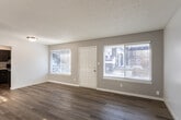 Located at 305 S Elm St in Boise, Idaho, this single-floor unit offers a clean, contemporary aesthetic defined by light wood-look flooring that runs consistently throughout every room. The living area is generously proportioned, featuring neutral gray walls, a textured ceiling, and multiple windows fitted with horizontal blinds that allow abundant natural light to fill the space. A dedicated entry door provides a straightforward, functional entryway directly from this main living area.

The kitchen is thoughtfully designed with dark espresso-toned shaker-style cabinetry, marble-patterned countertops, a stainless steel double-basin sink, and a full suite of stainless steel appliances including a dishwasher, electric range, and refrigerator. Ample upper and lower cabinet storage makes this kitchen both practical and visually striking.

Both bedrooms are well-sized, bright spaces with neutral walls and louvered bi-fold closet doors providing accessible storage. Natural light enters each bedroom through windows overlooking the surrounding neighborhood.

The bathroom features a full soaking tub with large-format gray tile surround, offering a clean and modern finish. Consistent wood-look flooring flows into the bathroom, maintaining a cohesive aesthetic throughout the unit. Overall, the space presents a polished, move-in-ready environment with updated finishes and a bright, airy ambiance.
