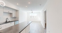 Located at 36101 Inland Valley Drive in Wildomar, CA, this thoughtfully designed one-bedroom, one-bathroom residence offers a clean, modern aesthetic across a single floor. The open-concept layout seamlessly connects the kitchen and living room, maximizing the sense of space and encouraging easy movement throughout.

The kitchen is a standout feature, showcasing crisp white cabinetry with matte black hardware, striking dark quartz countertops with white veining, and a textured tile backsplash. A central island provides additional prep space and casual seating potential. Stainless steel appliances, including a gas range, over-the-range microwave, dishwasher, and refrigerator, complete the well-appointed culinary space. Recessed lighting illuminates the area efficiently.

Light wood-look flooring extends throughout the home, creating a warm, cohesive feel. The living room receives natural light through a window fitted with blinds and is equipped with a ceiling fan. The bedroom is a comfortable, well-proportioned retreat with a window offering exterior views, a ceiling fan, and continued wood-look flooring.

The bathroom features white cabinetry with matching dark quartz countertops, a tub-shower combination, and a wall-mounted grab bar. A closet and hallway round out the functional layout of this well-designed Wildomar residence.