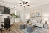 This thoughtfully designed 2-bedroom, 1-bathroom home offers a comfortable and functional single-floor layout. The open-concept living, dining, and kitchen area forms the heart of the home, anchored by wood-look vinyl flooring and crown molding throughout. The kitchen is outfitted with white cabinetry, granite-style countertops, a white subway tile backsplash, and a full suite of stainless steel appliances including a refrigerator, range, microwave, and dishwasher. A breakfast bar with bar seating connects the kitchen to the main living area, while a pendant chandelier illuminates the adjacent dining space. The living room features a ceiling fan, vaulted accent ceiling, and a glass door that invites natural light and outdoor views. Both bedrooms are generously proportioned with plush carpeting, ceiling fans, and ample natural light from large windows. Each bedroom is served by a dedicated walk-in closet with wire shelving. The bathroom offers a dual-sink vanity with granite-style countertops, wood-look flooring, and a large mirror. A dedicated laundry room with hookups completes the home's practical layout, making it a well-rounded and move-in ready residence.