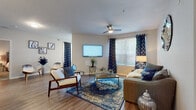 Located at 12065 Tuscany Bay Dr in the desirable Westchase community of Tampa, FL, this single-floor residence offers a thoughtfully designed open-concept layout that maximizes both comfort and functionality. The spacious living area features wood-look flooring, a ceiling fan, and large windows dressed with blinds and decorative curtains that allow generous natural light to fill the room. The open flow connects seamlessly to a breakfast bar and kitchen, which is equipped with stainless steel appliances — including a refrigerator, range, and microwave — white cabinetry, light quartz countertops, and a classic subway tile backsplash. A dedicated workspace nook with a window provides an ideal area for a home office setup. The residence includes two well-proportioned bedrooms, each with plush carpet flooring, ample closet space, and windows that invite natural light. The bathrooms are finished with wood-look flooring and include a full tub-shower combination. A convenient in-unit laundry area with cabinetry adds practical storage. The neutral color palette and consistent finishes throughout create a cohesive, inviting ambiance suited to a variety of lifestyles.