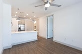Located on Cerrillos Ave in Midland, Texas, this single-floor residence showcases a clean, contemporary design with a cohesive neutral palette and warm hardwood-style flooring that extends throughout the living areas. The open-concept kitchen serves as the heart of the space, featuring gray shaker-style cabinetry, crisp white quartz countertops, and a full suite of stainless steel appliances including an electric range, built-in microwave, dishwasher, and refrigerator. A peninsula with an undermount sink and stylish industrial pendant lights overhead enhances both functionality and visual appeal, while a classic subway tile backsplash adds a refined finishing touch. The kitchen flows naturally into the living area, which is brightened by natural light streaming through large windows dressed with blinds. The bedroom continues the consistent design language, offering hardwood-style flooring, a ceiling fan, and a well-proportioned window that fills the room with daylight. The bathroom is neatly appointed with a white quartz vanity, shaker-style cabinetry, a framed mirror with contemporary lighting, and chrome fixtures. Throughout the space, recessed lighting and thoughtful details contribute to a bright, welcoming ambiance well-suited to modern living.