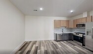 Located at 448 S Orange Ave in Newark, NJ, this thoughtfully designed one-bedroom, one-bathroom residence offers a modern living experience across a single floor. The open layout maximizes every inch of the space, with light-toned luxury vinyl plank flooring flowing consistently throughout, complemented by crisp white walls and recessed lighting that create a bright, clean aesthetic.

The kitchen is a standout feature, equipped with full-size stainless steel appliances — including a gas range, over-the-range microwave, dishwasher, and French door refrigerator. Light wood shaker-style upper cabinets are paired with charcoal lower cabinets, topped with white countertops and accented by a classic white subway tile backsplash. A matte black faucet adds a modern finishing touch.

The living area is generously proportioned, offering flexibility for various furniture arrangements, with recessed lighting overhead and easy access to closet storage via double doors with matte black hardware. The bedroom is a comfortable size, featuring a bright window that brings in natural light.

The bathroom is elegantly finished with floor-to-ceiling marble-look tile in the tub/shower surround, a white vanity with matte black fixtures, a framed mirror, and modern sconce lighting — delivering a spa-like atmosphere. This unit combines contemporary design with functional living in the heart of Newark.